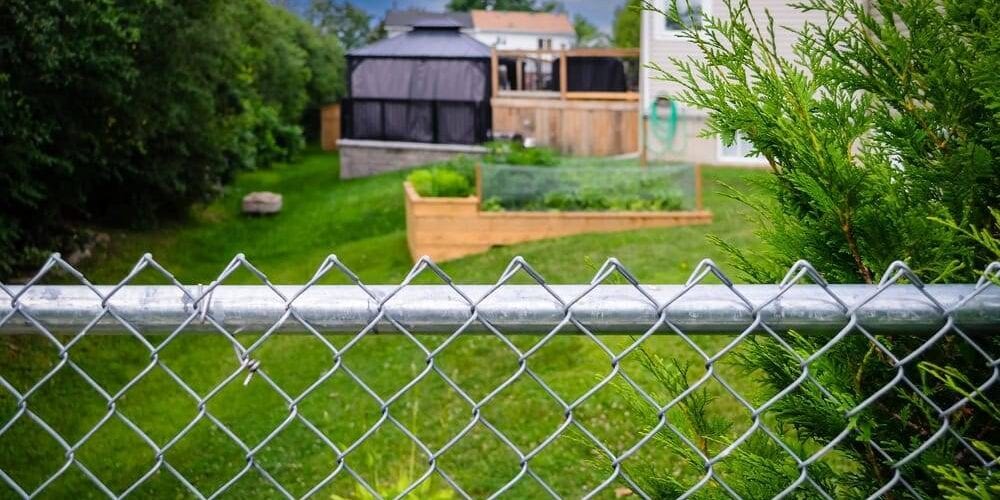 Suburban,Backyard,Decks,,Gazebo,And,Garden,Behind,A,Chain-link,Fence garden behind a chain link fence
