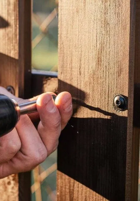 hand of carpenter installing fence